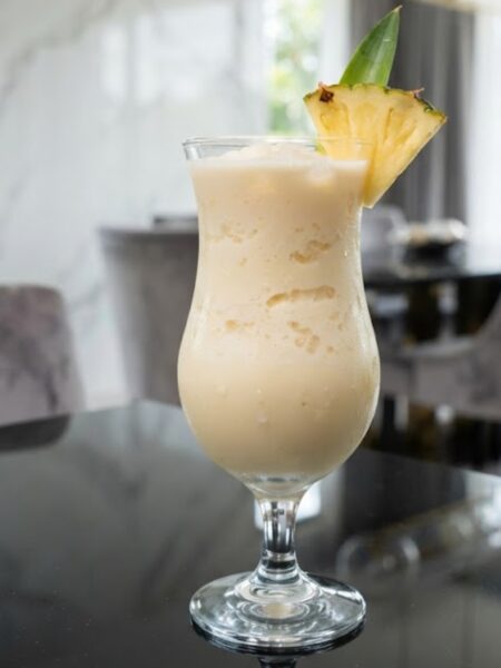 Creamy virgin piña colada made with pineapple juice, coconut milk, crushed ice, and fresh pineapple garnish